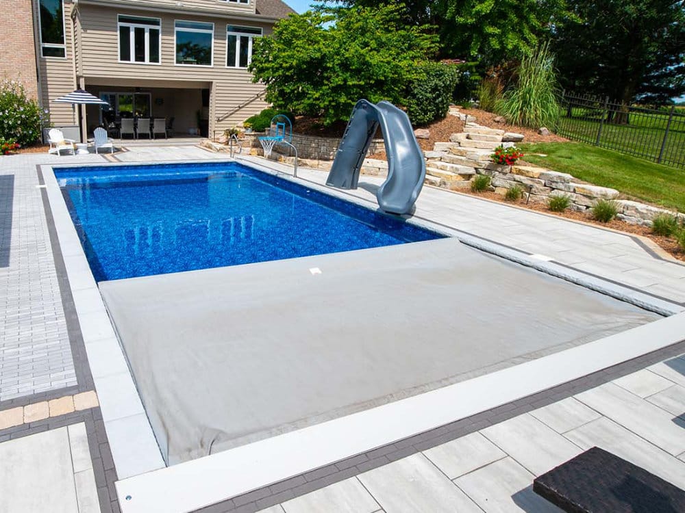 Automatic pool cover on an in-ground rectangular fiberglass pool