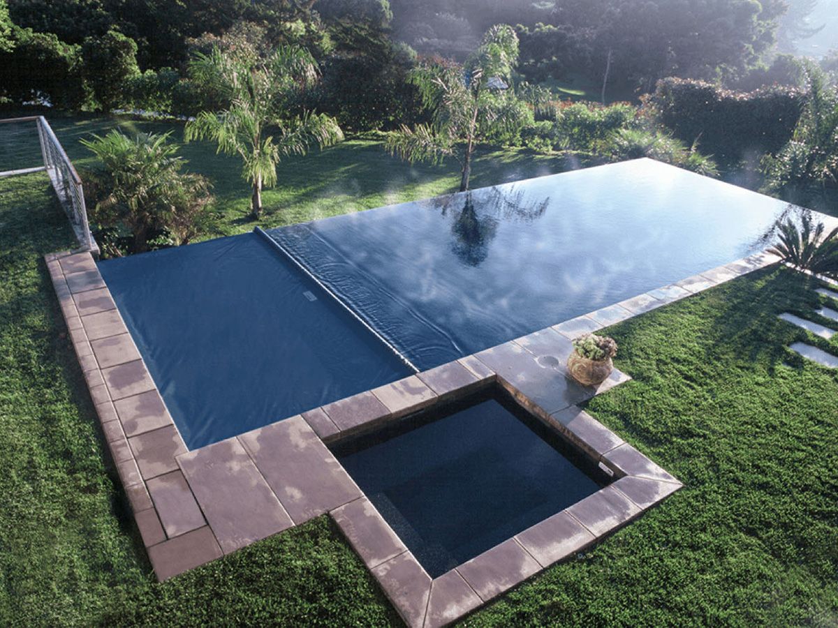 Eclipse automatic pool cover from Coverstar covering a backyard fiberglass in-ground pool.