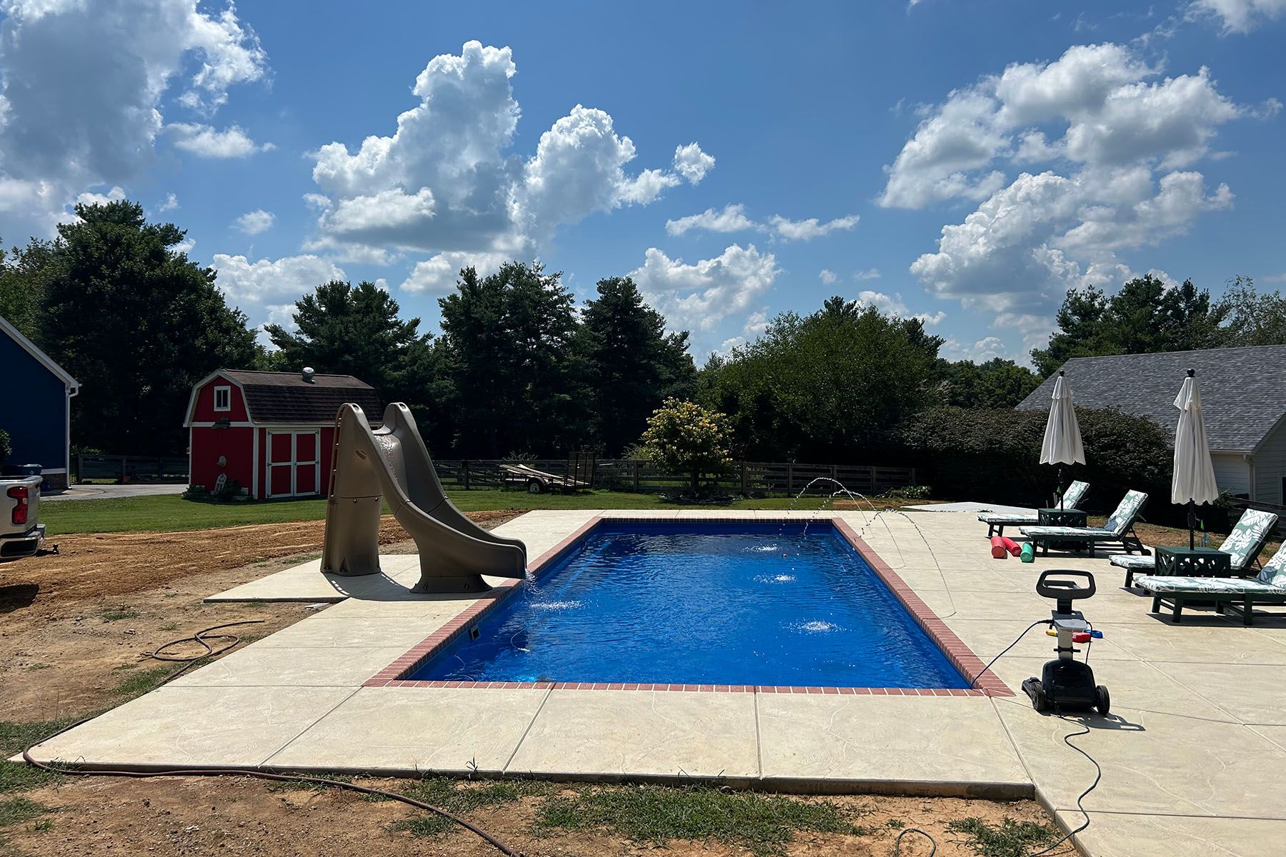 In-ground rectangle fiberglass pool with a slide in Goshen, Kentucky.