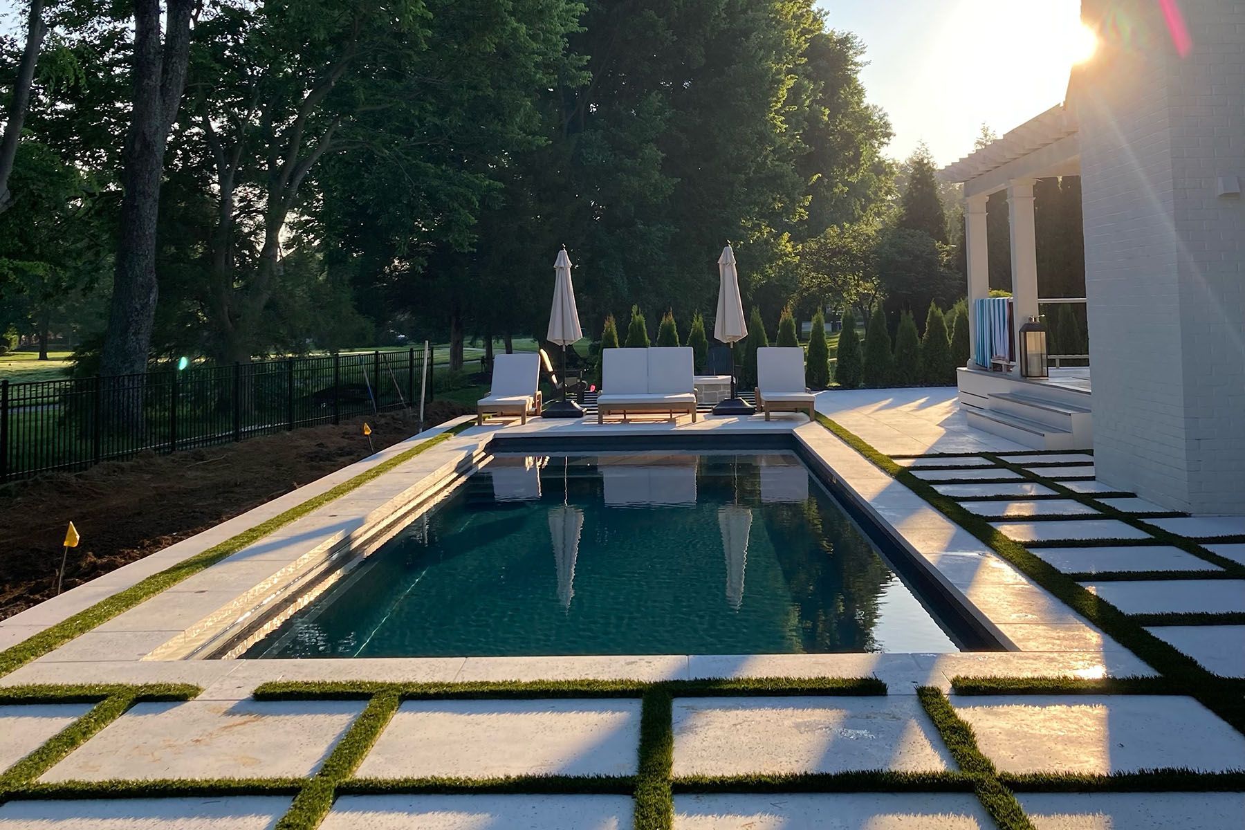 Rectangular in-ground fiberglass swimming pool behind white house in Louisville, Kentucky.