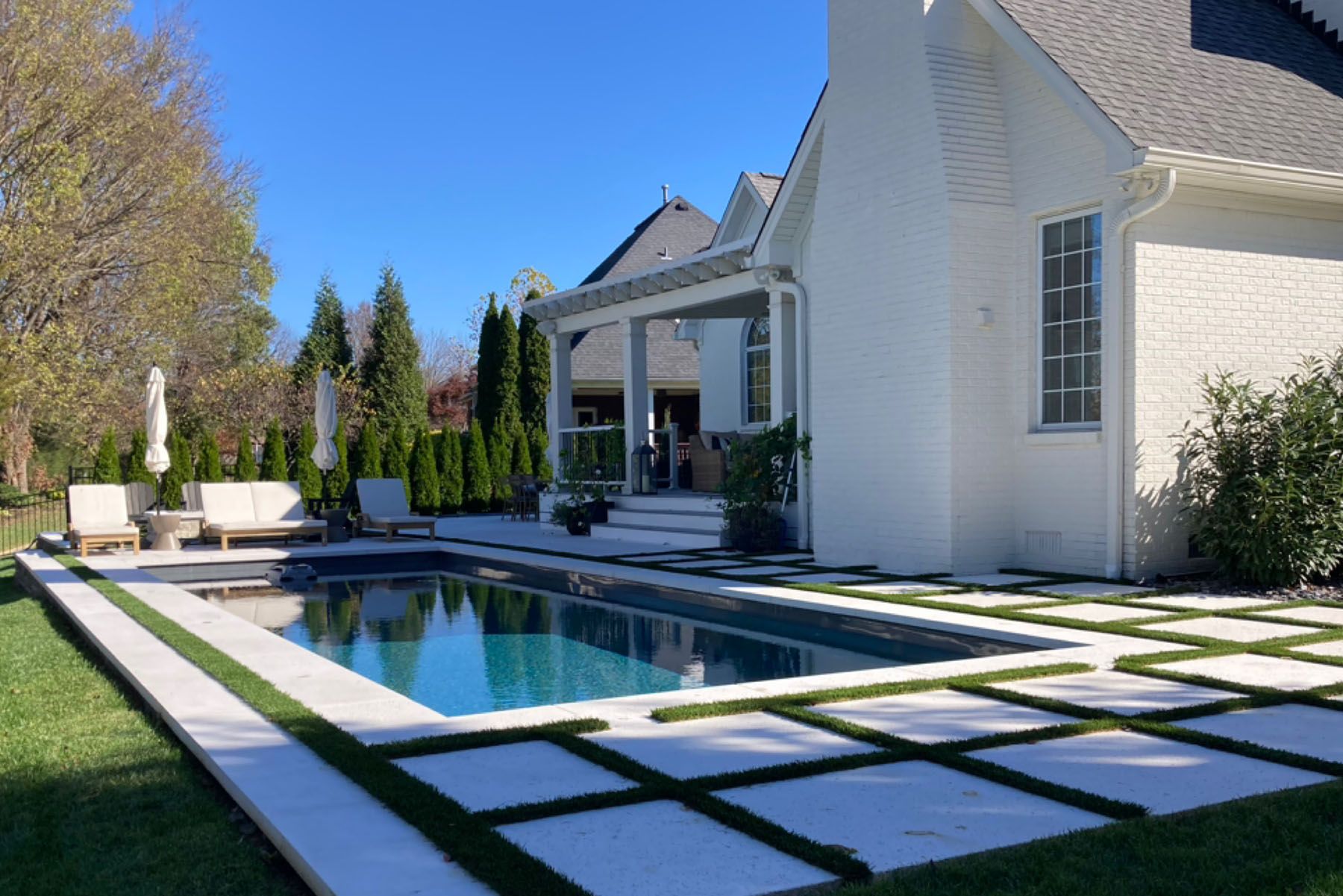 Rectangular in-ground fiberglass swimming pool behind white house in Louisville, Kentucky.