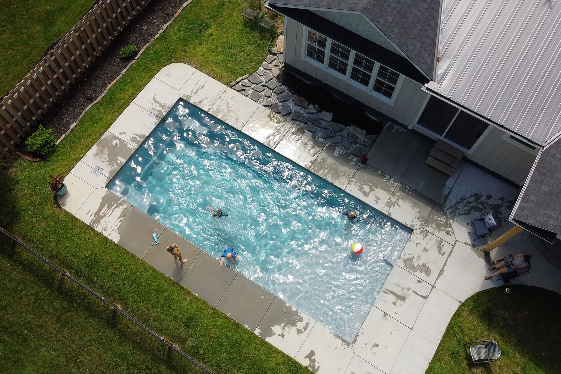 Aerial view of children playing in an in-ground fiberglass swimming pool in Louisville, Kentucky.
