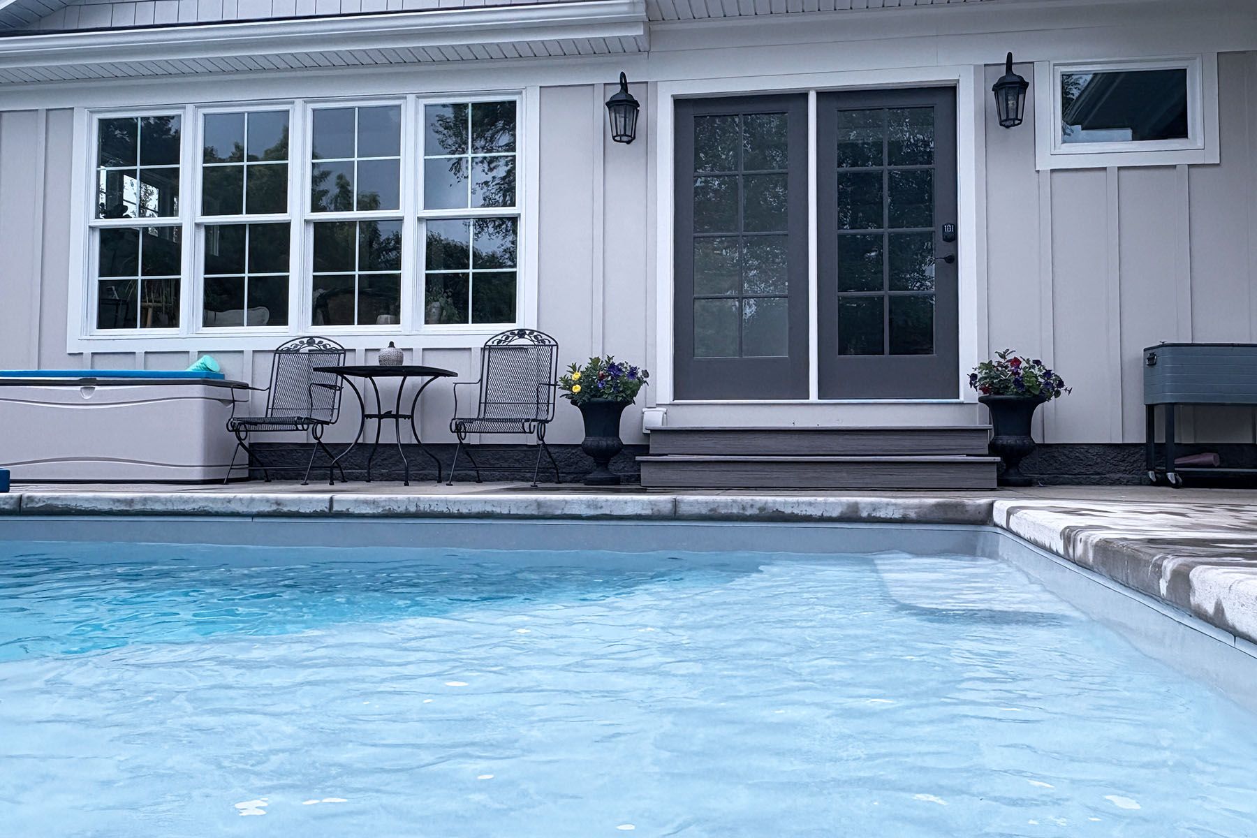 Back of a house in Louisville Kentucky with a fiberglass in-ground pool just outside the back door.