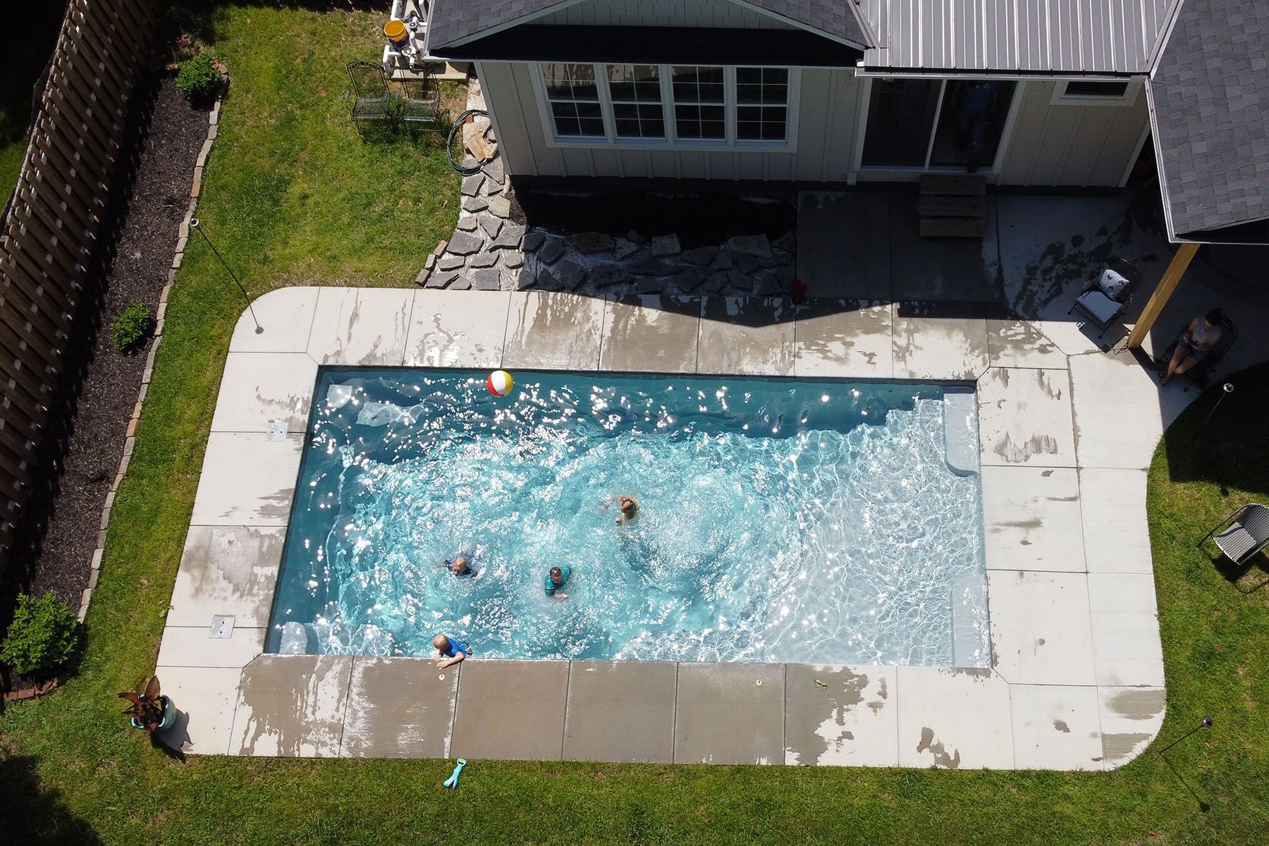 Aerial view of children playing in an in-ground fiberglass swimming pool in Louisville, Kentucky.