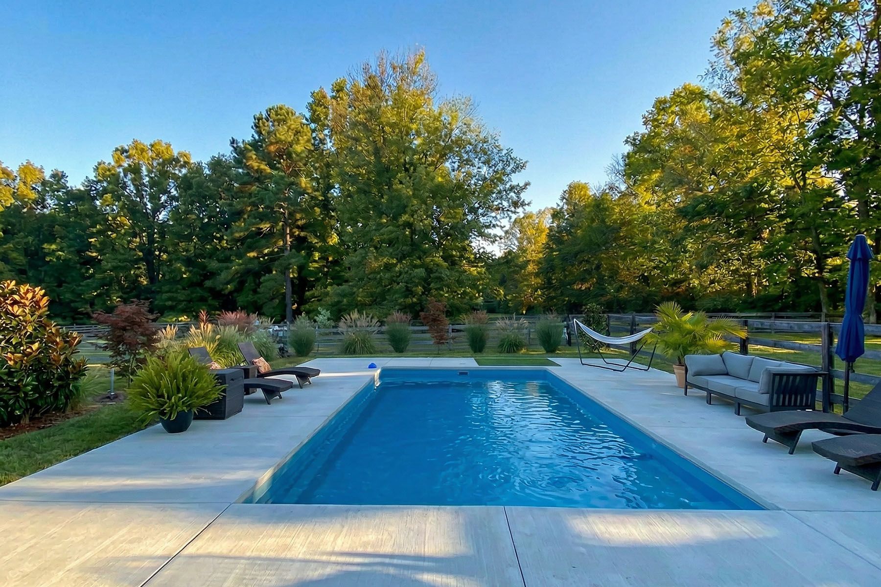 Rectangular in-ground fiberglass swimming pool in a nicely landscaped backyard in Prospect, Kentucky.