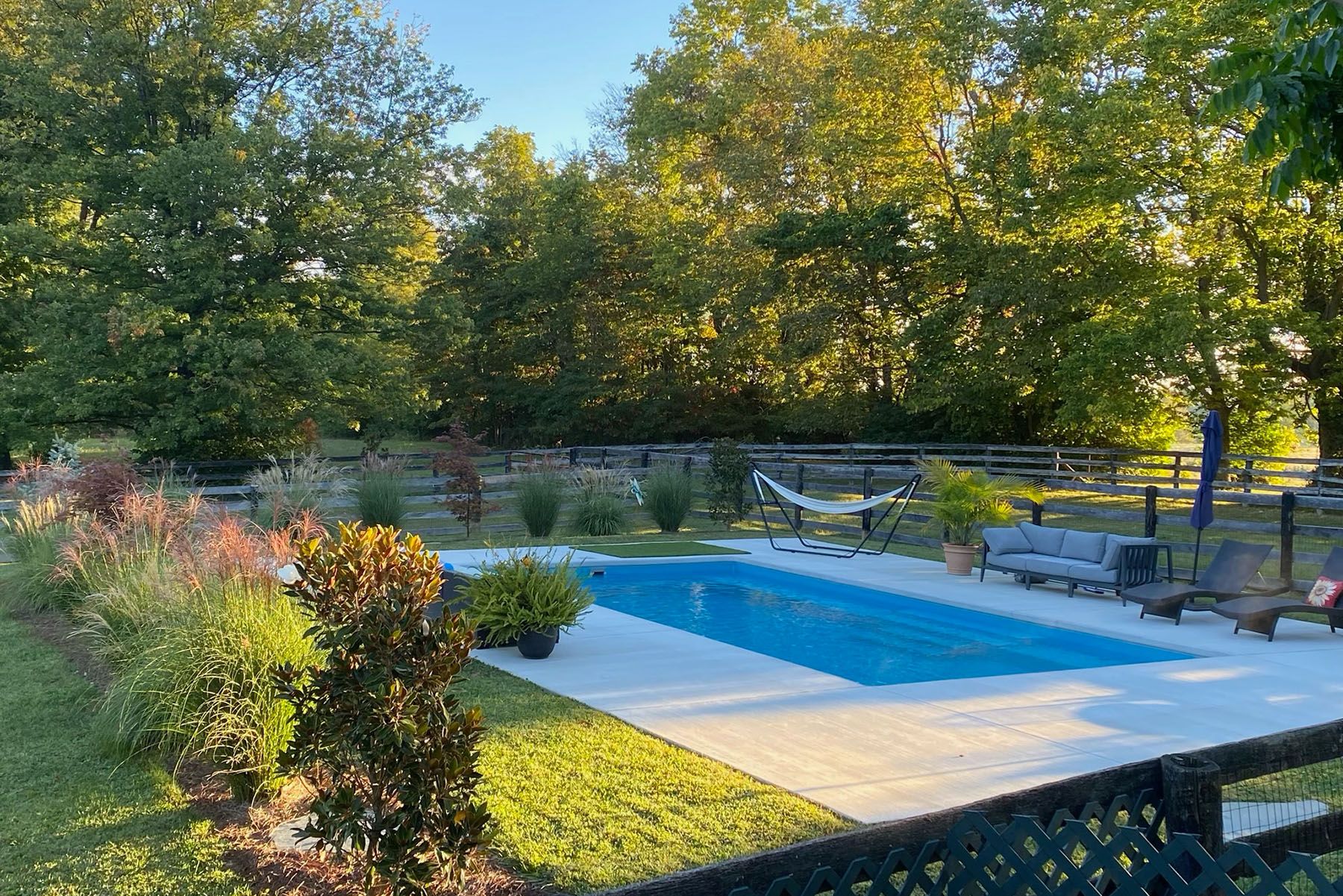 Rectangular in-ground fiberglass swimming pool in a nicely landscaped backyard in Prospect, Kentucky.
