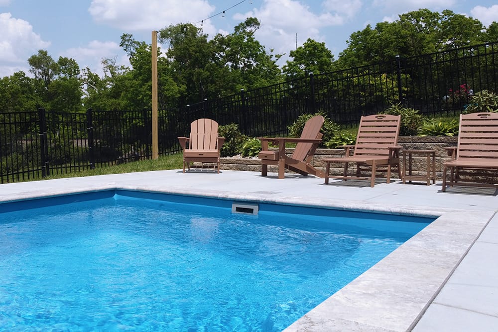 Rectangular in-ground fiberglass swimming pool surrounded by a concrete patio in Shelbyville, Kentucky.