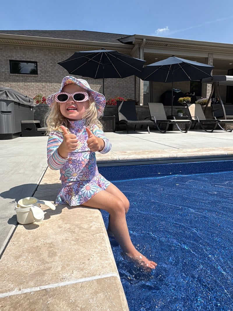 Young girl sitting on the edge of a backyard pool in Kentucky